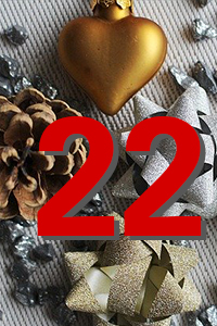 Nahaufnahme weihnachtlicher Dekoration: goldenes Herzornament, Tannenzapfen, glitzernder Stern und silberne Kugel, darüber große rote Zahl "22".