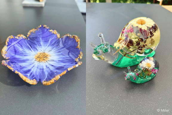Zwei dekorative Glasobjekte: links eine blau-blütenförmige Schale mit goldgerandeten Zacken und hellem, sternförmigem Zentrum; rechts zwei grüne Glas-Schnecken mit transparenten, mit getrockneten Blumen gefüllten Häuschen (groß und klein).