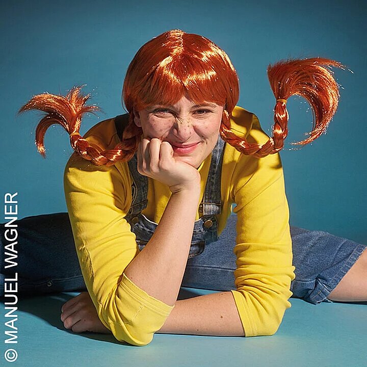 Frau mit roten Locken lacht und hält zwei bunte Luftballons in den Händen. (KI generiert)
