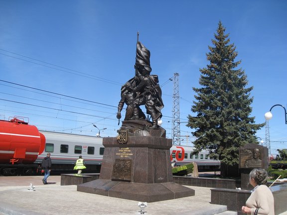 Eine große Statue in der Stadt Tula und ein Zug im Hintergrund.