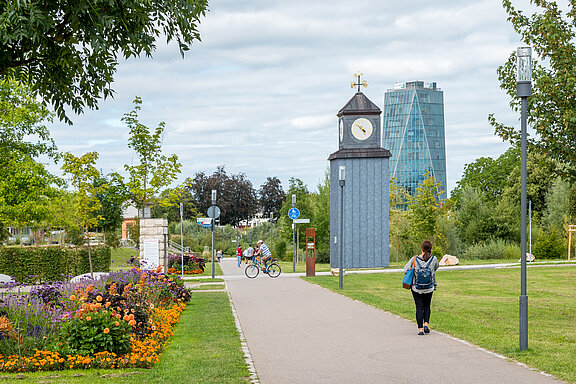 Eine Person spaziert durch den Neckarpark in Schwenningen bei gutem Wetter.