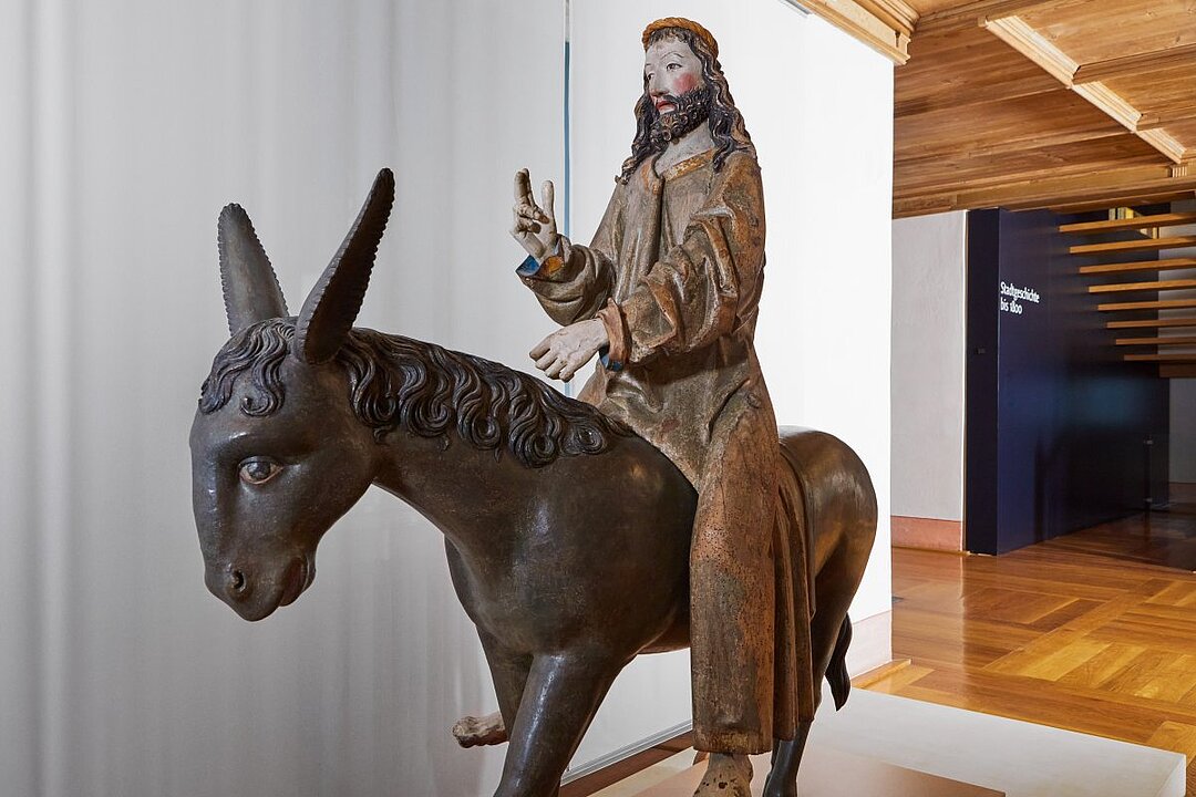 Bronzestatue eines Mannes mit Ziegenbart auf einem Widder reitend, hält ein Zepter. (KI generiert)