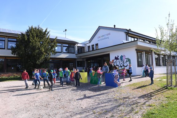 Gebäude der Grundschule Obereschach mit dutzenden Kinder, die vor der Schule spielen. 