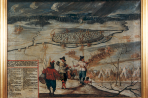 Historisches Gemälde einer winterlichen Belagerung: ringförmige befestigte Stadt, umgeben von Truppenlagern und brennenden Stellen; im Vordergrund Soldaten auf einem Hügel und ein Zeltlager; links unten Texttafel.