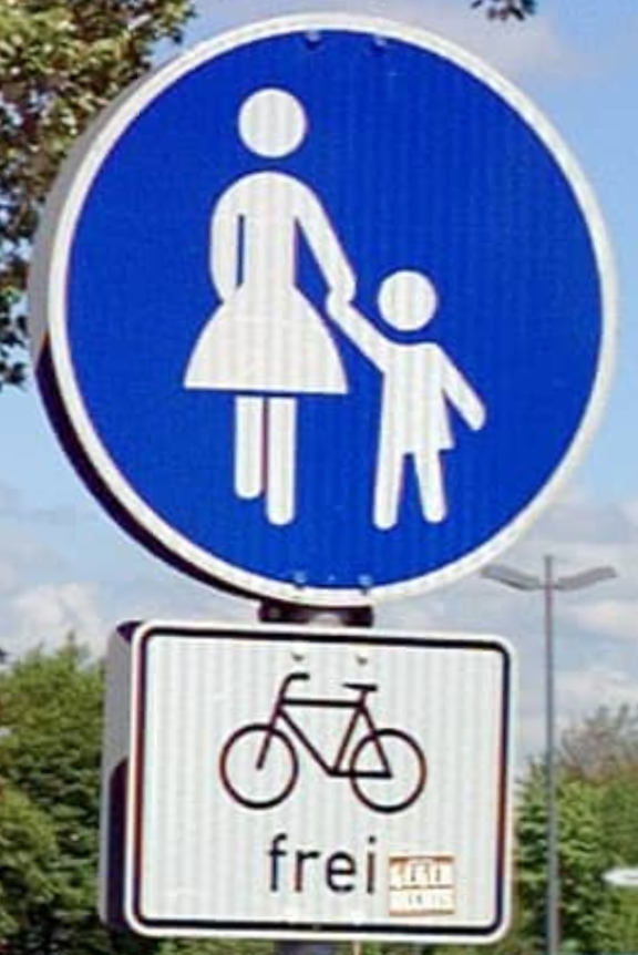 Blaues Schild mit weißem Fußgänger und Kind. Daraunter ein Fahrradsymbol mit der Aussage frei.