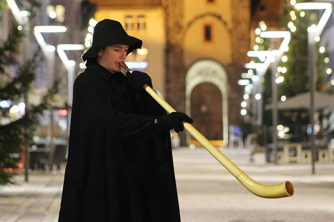Eine Person spielt eine traditionelle Flöte in der Nacht. (KI generiert)