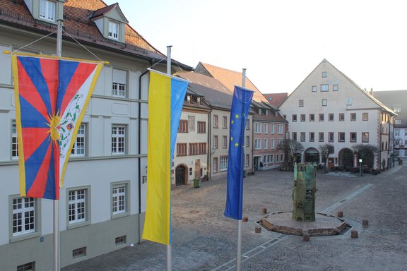 Drei Flaggen von Tibet, der Ukraine und der EU wehen jeweils an einem Fahnenmast auf dem Villinger Münsterplatz.