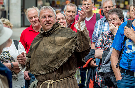 ein verkleideter Stadtführer zeigt einigen Besuchern die Sehenswürdigkeiten im Stadtbezirk Villingen
