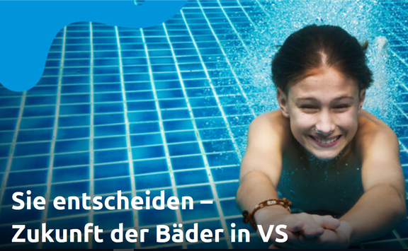 Mädchen schwimmt lächelnd unter Wasser mit ausgestreckten Armen in einem blau gefliesten Schwimmbecken, auf die Kamera zu.