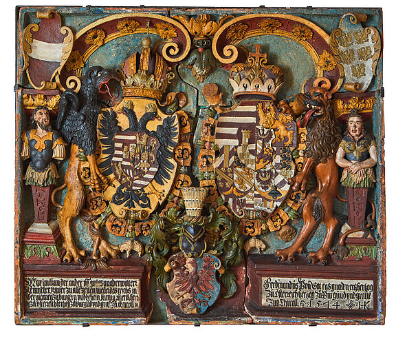 Bemalte geschnitzte Holztafel mit zwei gekrönten Wappenschilden, links Adler, rechts Löwe als Schildhalter, reich verzierte Ornamente, Helme und kleine Figuren.