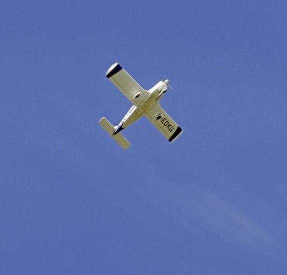 Ein fliegendes Modellflugzeug vor blauem Himmel 